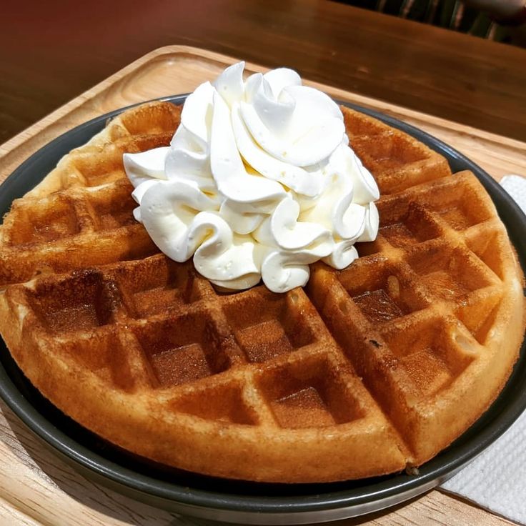 a waffle topped with whipped cream on a plate