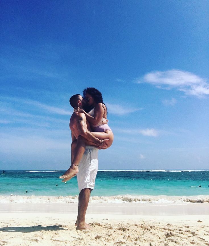 a man carrying a woman on the beach