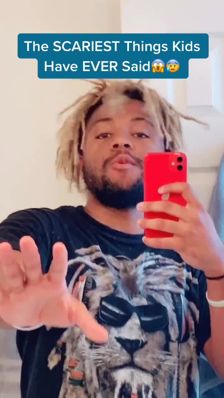 a man with dreadlocks is holding his cell phone and pointing at the screen