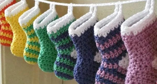 crocheted mitts hanging from a line on a clothesline in front of a door