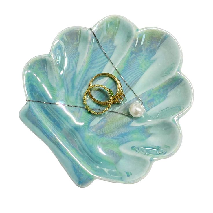 a blue shell with two gold rings and a pearl bead hanging from it's end