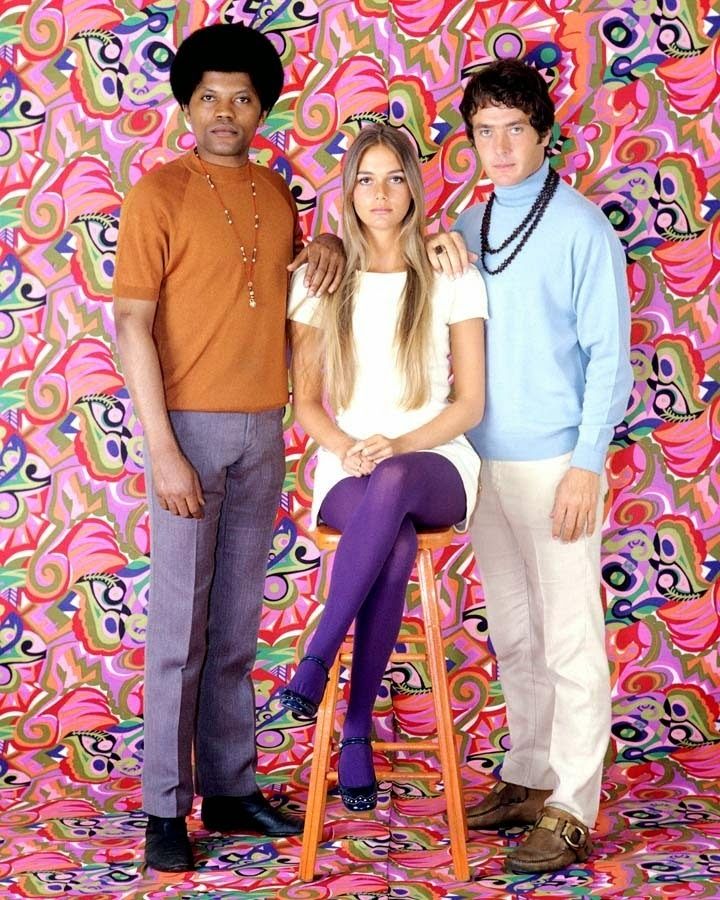 three people standing in front of a colorful backdrop