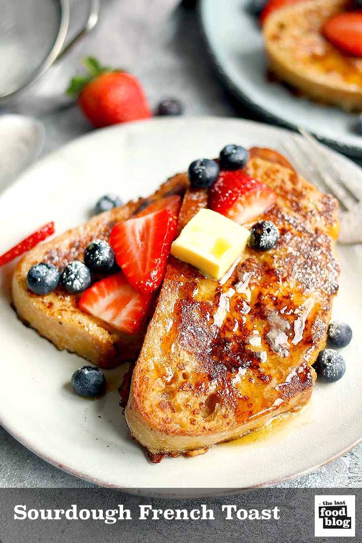 french toast topped with berries and butter on a white plate