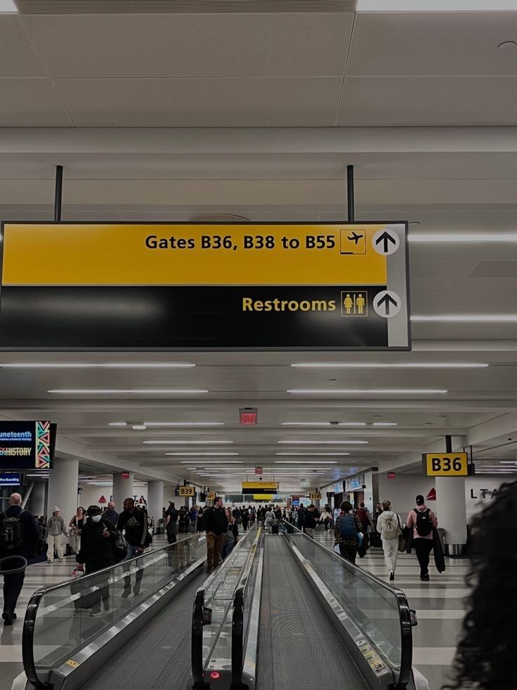 people are walking through an airport with their luggage on the conveyor belt and signs above them that read gates b36, b38 to bs5