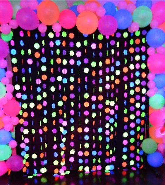 neon colored balloons and streamers in front of a black backdrop