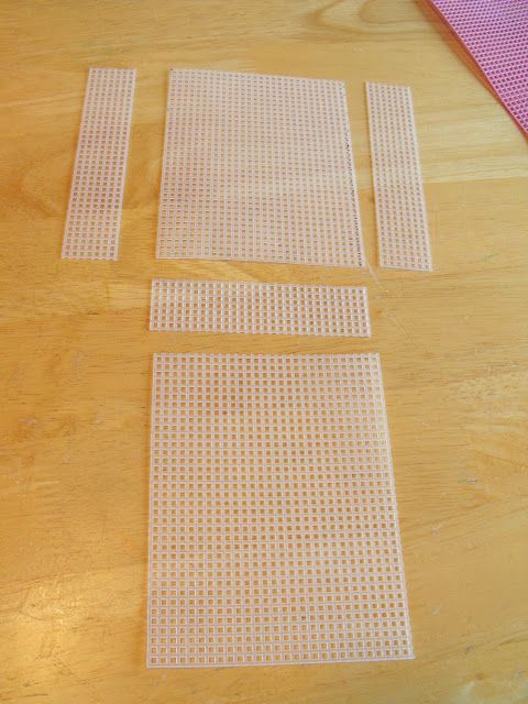 three pieces of white mesh sitting on top of a wooden table next to a pink towel