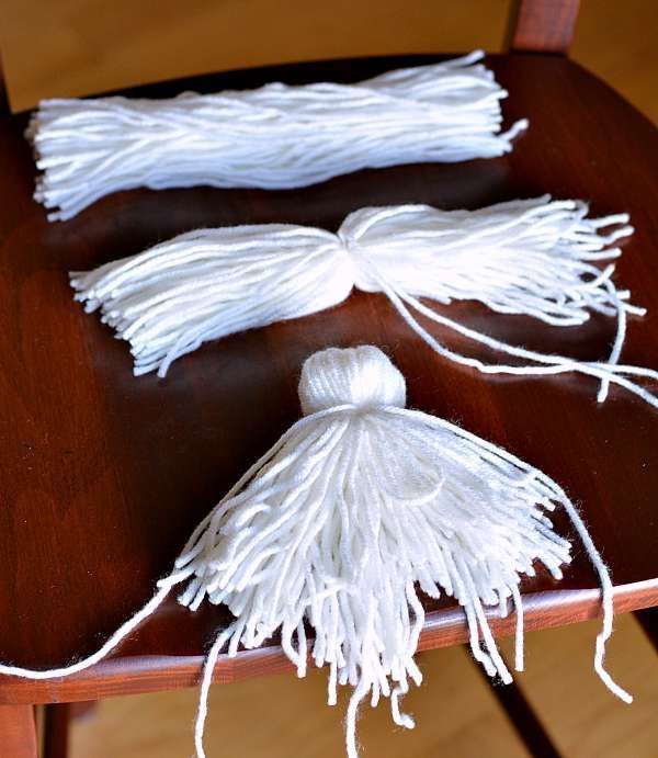 two white tassels on a wooden chair