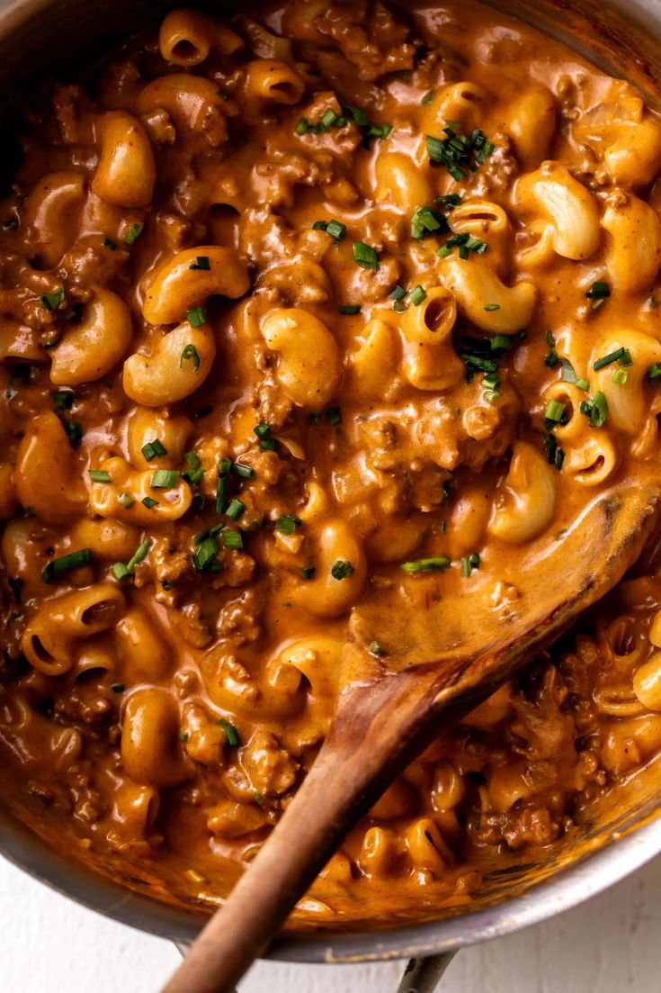 macaroni and cheese in a pot with a wooden spoon