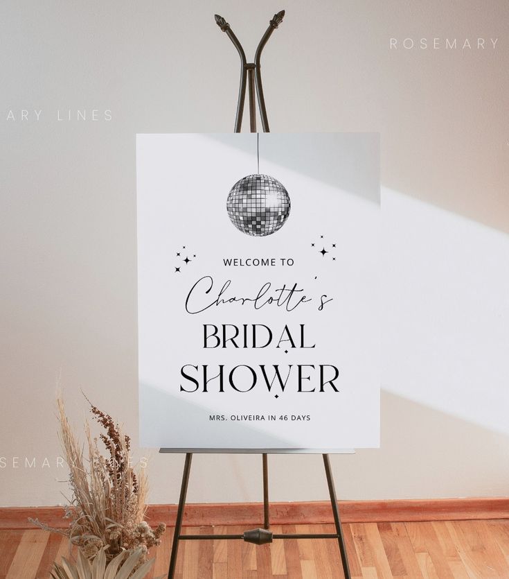 a welcome sign for a bridal shower is displayed on an easel in front of a white wall