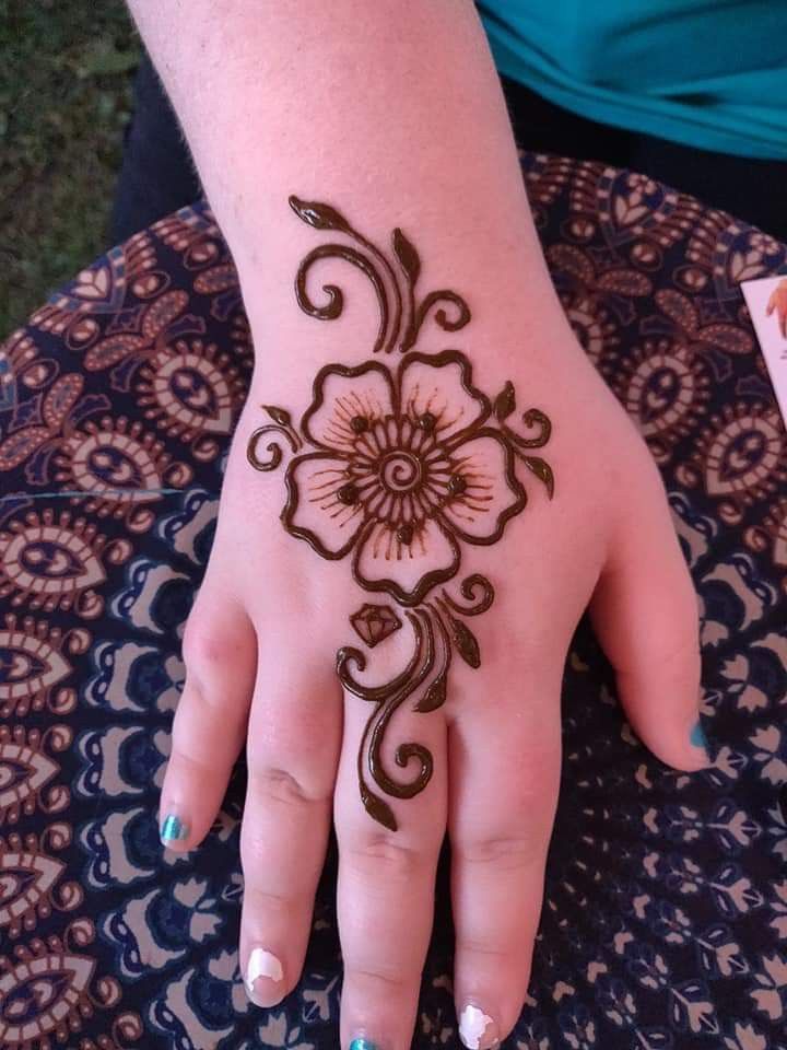 a woman's hand with henna tattoos on it