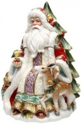 a santa claus figurine holding an apple next to a deer