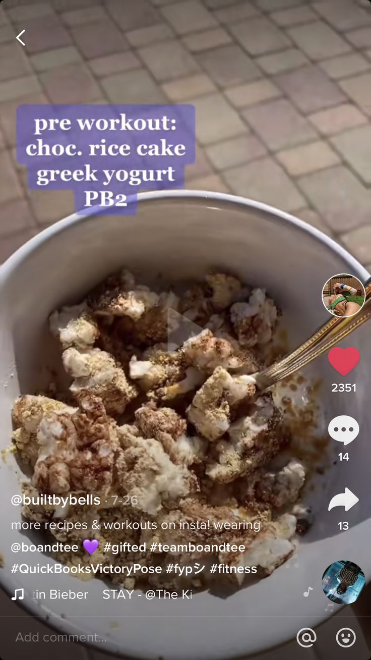 a bowl filled with food sitting on top of a table next to a cell phone