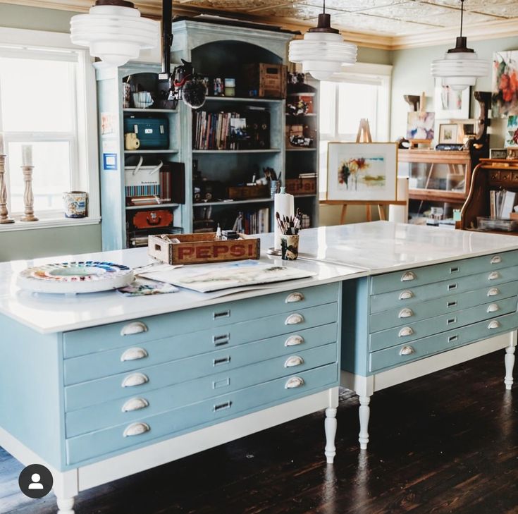 a large kitchen island with lots of drawers on top of it in a room filled with furniture