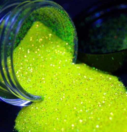 a jar filled with yellow and green glitter