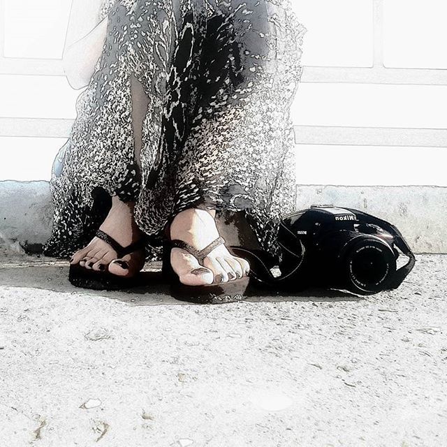 a woman is sitting on the ground with her feet up