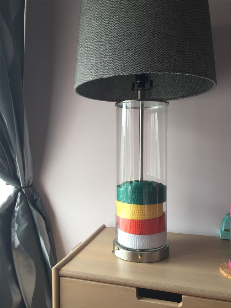 a lamp that is sitting on top of a wooden table next to a dresser and window