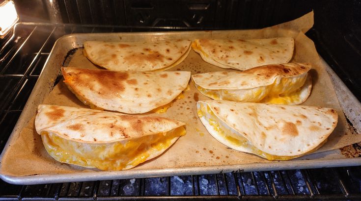 some tortillas are on a baking sheet in the oven