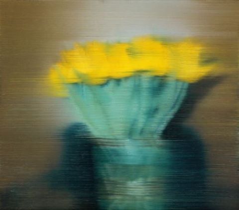 a vase with yellow flowers in it sitting on a table