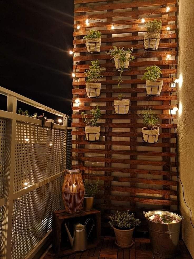 an outdoor deck with potted plants and lights