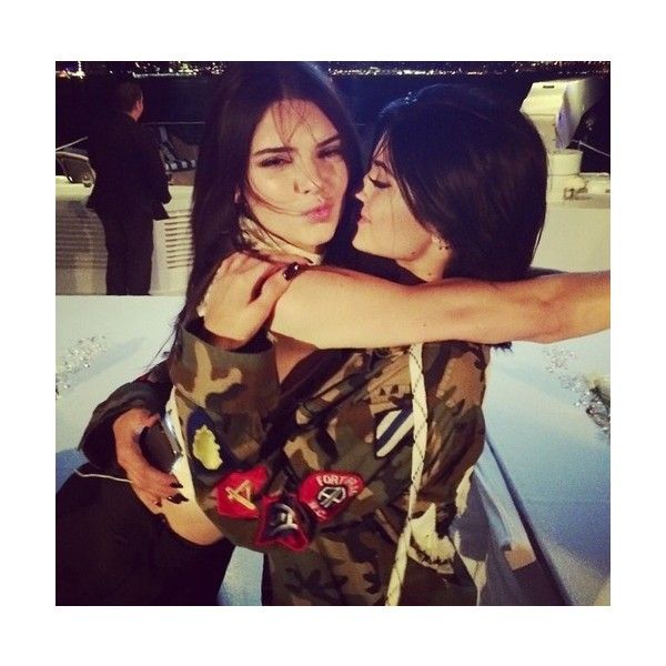 two young women hugging each other in front of a cityscape at night time