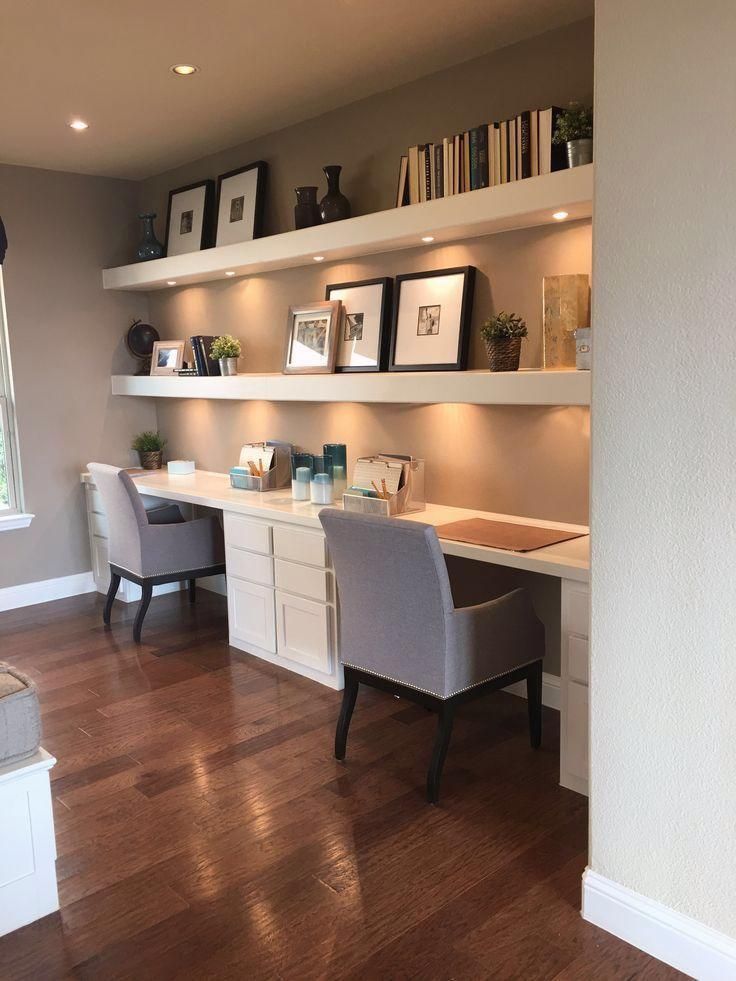 a home office with white shelving and wooden floors