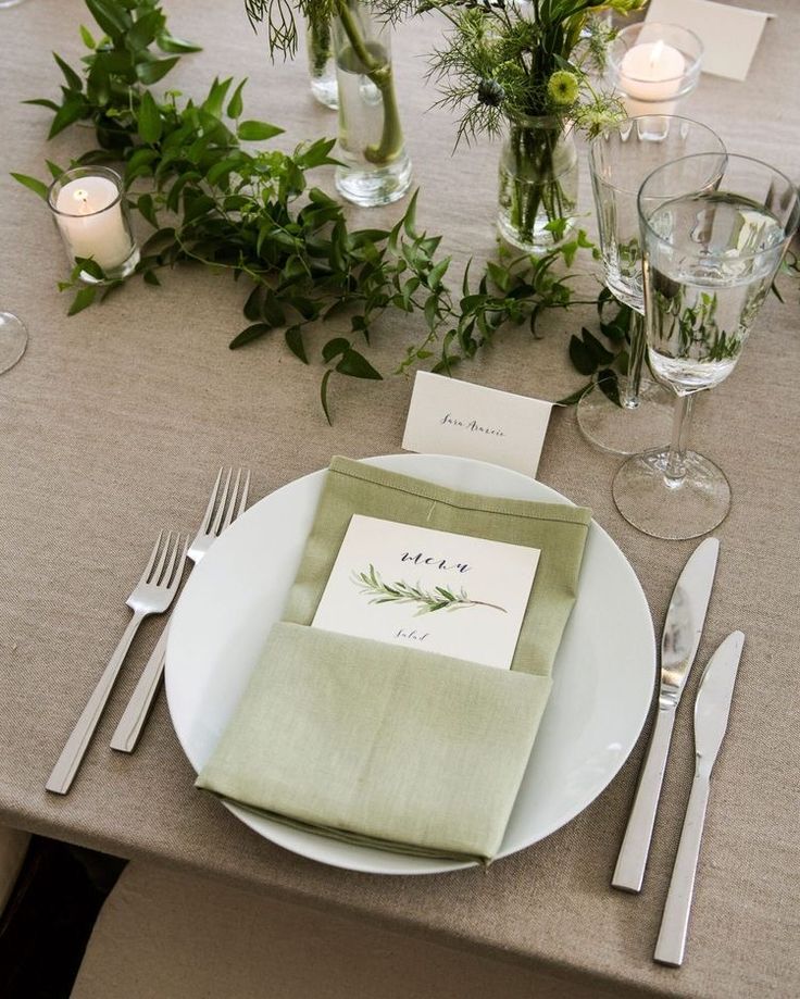 the table is set with silverware and place settings for guests to sit down at