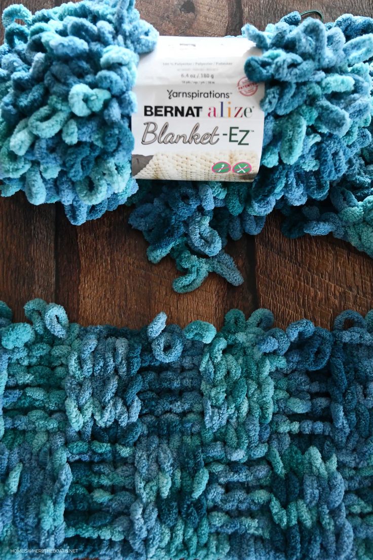 two blue crocheted rugs sitting on top of a wooden floor next to each other