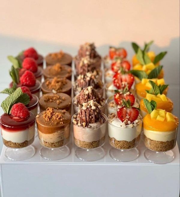 there are many small desserts on the white tray, each with different toppings