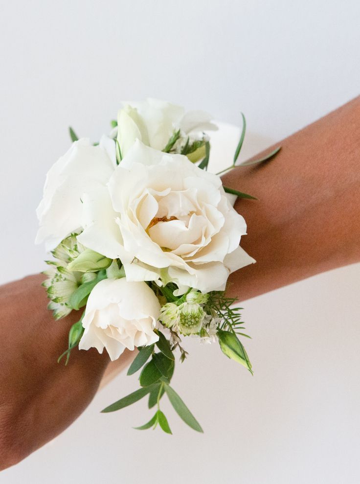 a bouquet of white flowers is being held by someone's arm on a white background