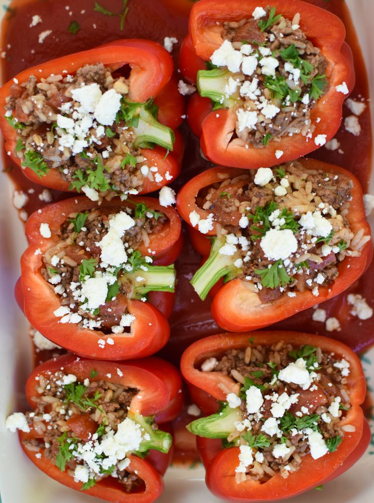 stuffed red peppers with feta cheese and parsley on top, ready to be eaten