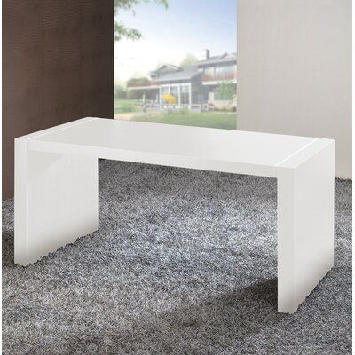 a white table sitting on top of a carpeted floor in front of a window