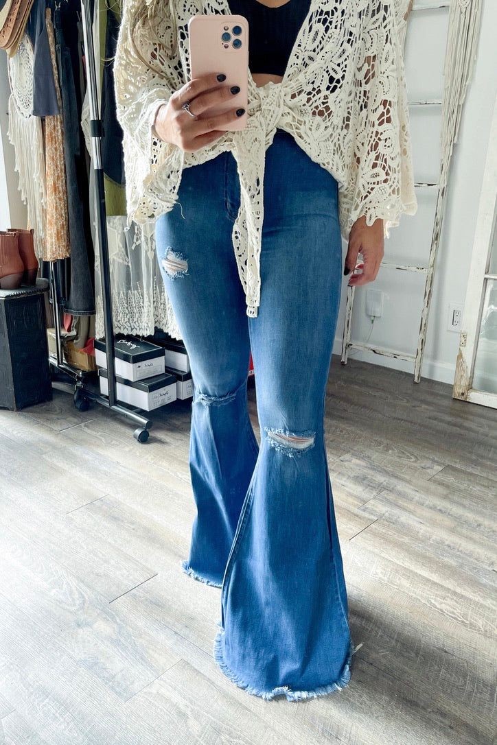 A pair of extreme flare jeans featuring a light distressed design, frayed raw hem, and ripped knee slits. These jeans offer two back patch pockets, faux front pockets, and a zip-fly closure.Rise: 11" Inseam: 34"Made In: Imported Fabric Contents: 73% Cotton, 14% Rayon, 11% Poly, 2% Spandex Distressed Cutoff Flare Jeans, Distressed Denim Flare Jeans With Cutoff, Distressed Denim Cutoff Flare Jeans, Distressed Denim Flare Jeans For Fall, Distressed Cutoff Flare Jeans For Fall, Fall Ripped Denim Flare Jeans, Fall Stretch Flares With Frayed Hem, Casual Distressed Denim Flares, Trendy Distressed Wide Leg Flares