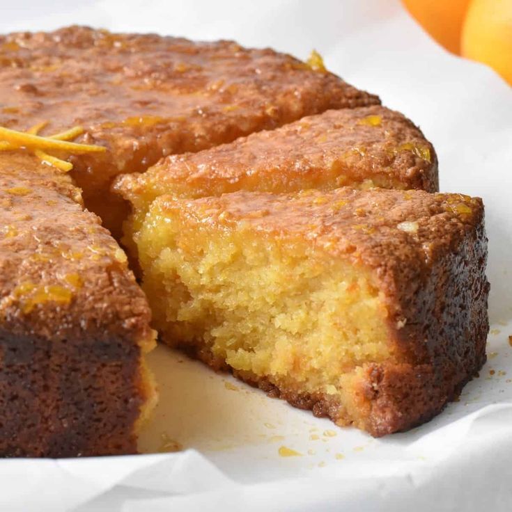 a close up of a piece of cake on a plate with oranges in the background