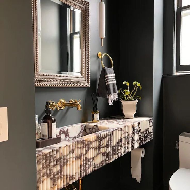 a bathroom with a sink, toilet and mirror