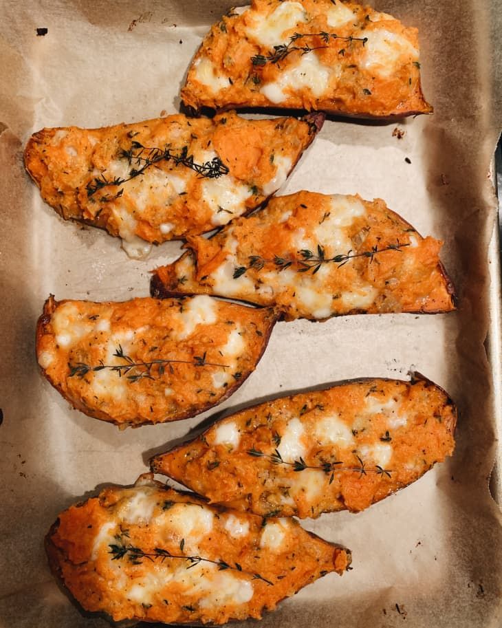 four pieces of chicken with cheese and herbs on them