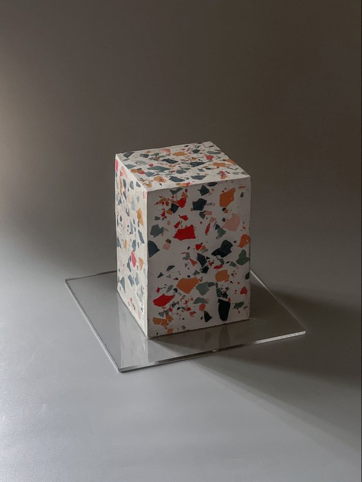 an artistically designed box sitting on top of a glass stand