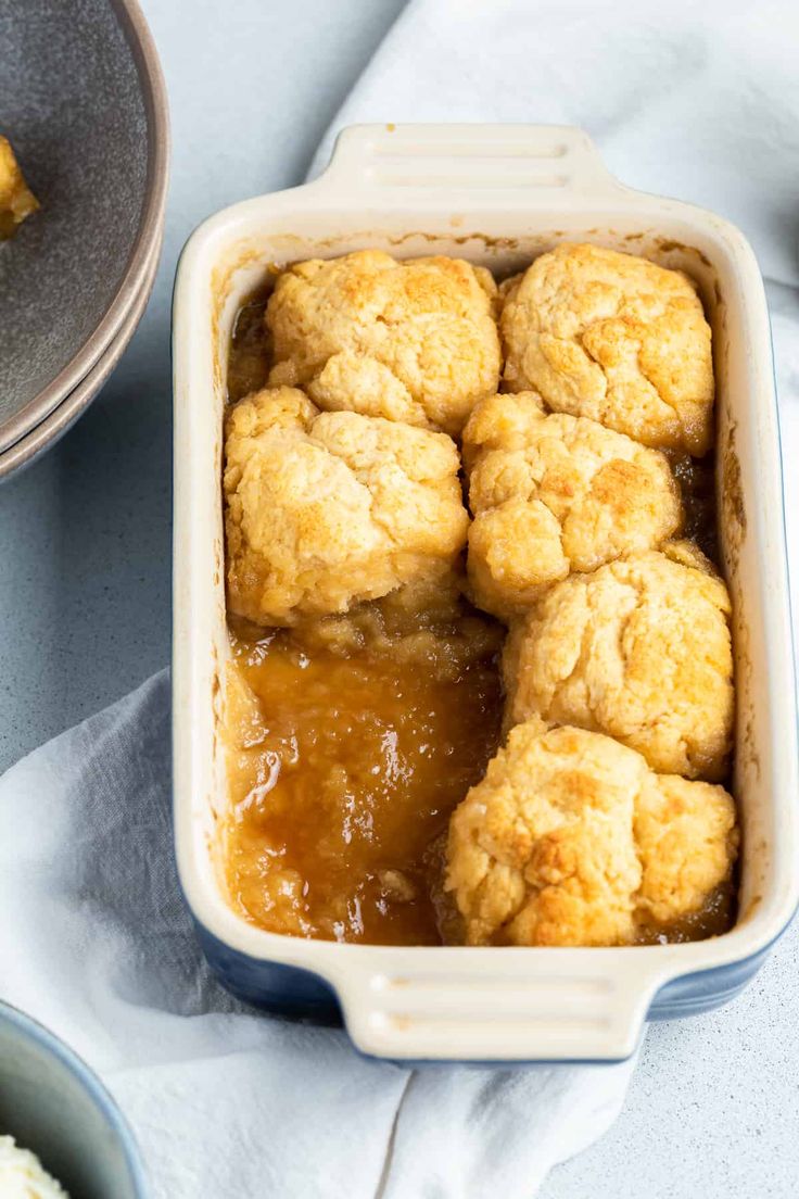 a casserole dish filled with baked goods next to other dishes