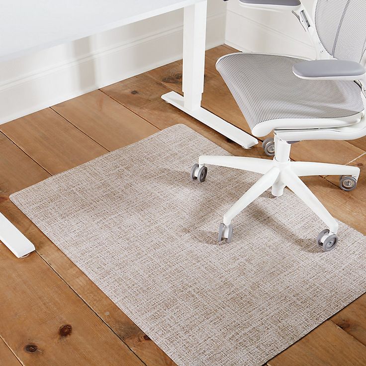 an office chair sitting on top of a wooden floor next to a desk with a computer