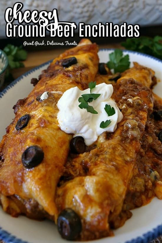 a white plate topped with enchiladas covered in sour cream and black olives