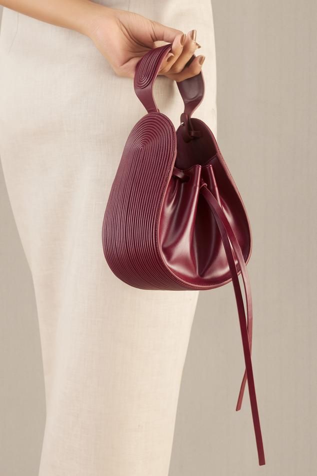 Wine corded bucket bag in faux leather with corded handle detail.
Composition: 100% PU/Faux Leather
Color: Wine
Other Details: 
Dimensions (in inches):
L x W x D: 6.5 x 3.5 x 7.5
Handle drop: 3.5
Closure: Adjustable drawcord - Aza Fashions Faux Leather Bag Diy, Classy Purses, Bilbo Baggins, Favorite Purse, Diy Leather Bag, Unique Handbags, Handbag Essentials, Buy Wine, Beautiful Handbags