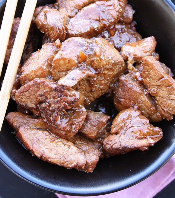 some meat and chopsticks are in a bowl