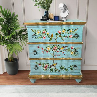 a blue painted dresser next to a potted plant