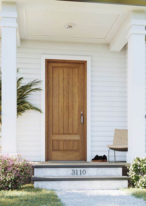 the front door of a white house with a chair and potted plant