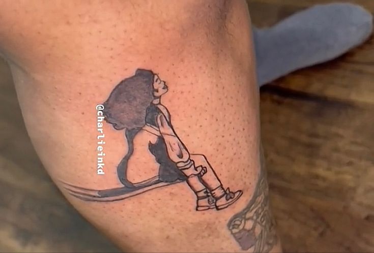 a tattoo on the leg of a person with a cat sitting on top of it