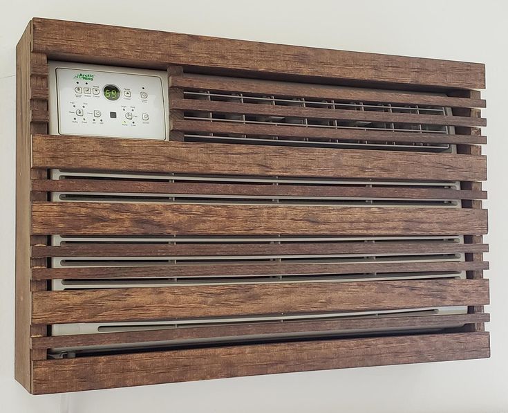 a wooden wall mounted air conditioner on the side of a white wall in a room