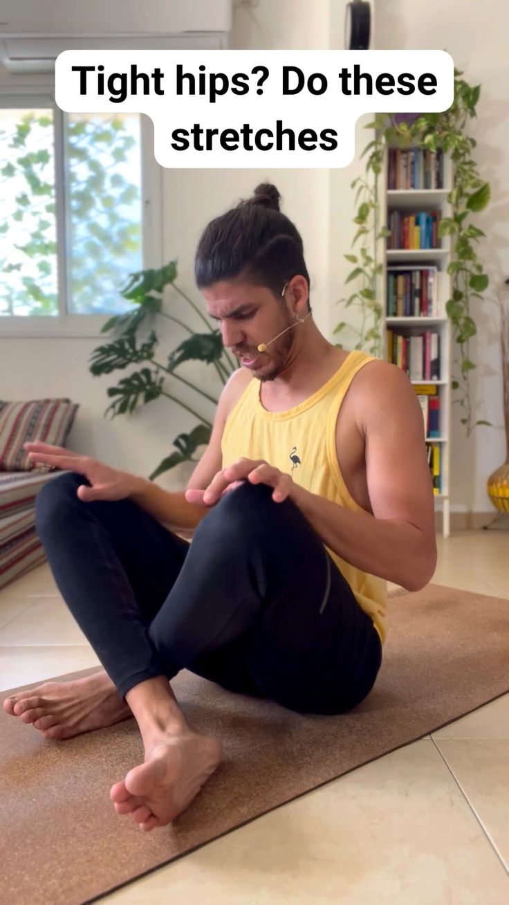 a man sitting on the floor looking at his cell phone with an ad above him that says, tight hips? do these stretches