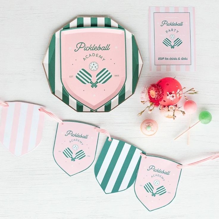 a pink and green striped paper plate next to other items on a white wooden table