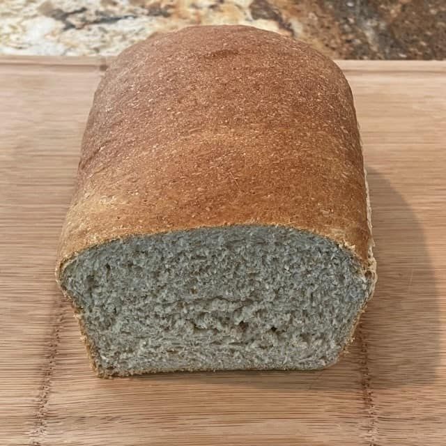 a loaf of bread sitting on top of a wooden cutting board