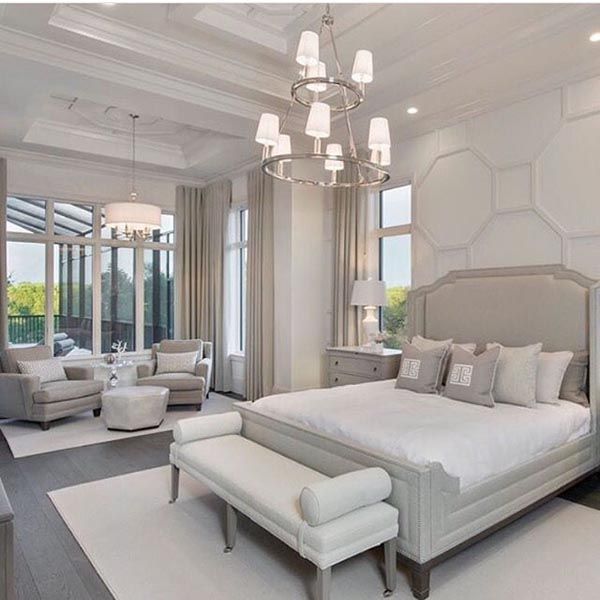 a large bedroom with white furniture and chandelier