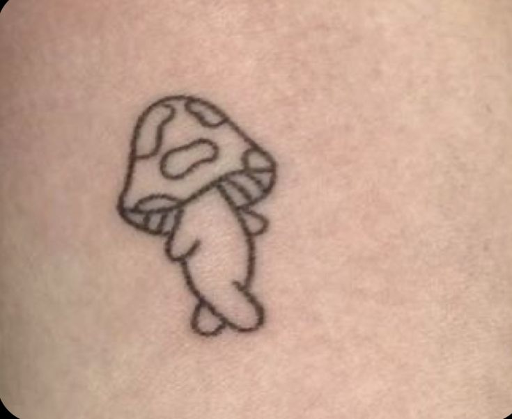 a small mushroom tattoo on the thigh